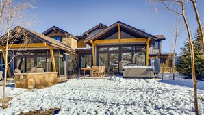 Une maison moderne dotée d’un grand patio, d’un jacuzzi et d’un espace salon aménagé et abrité.