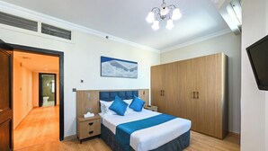 Een slaapkamer met een bed, nachtkastjes, een kledingkast en een schilderij aan de muur.