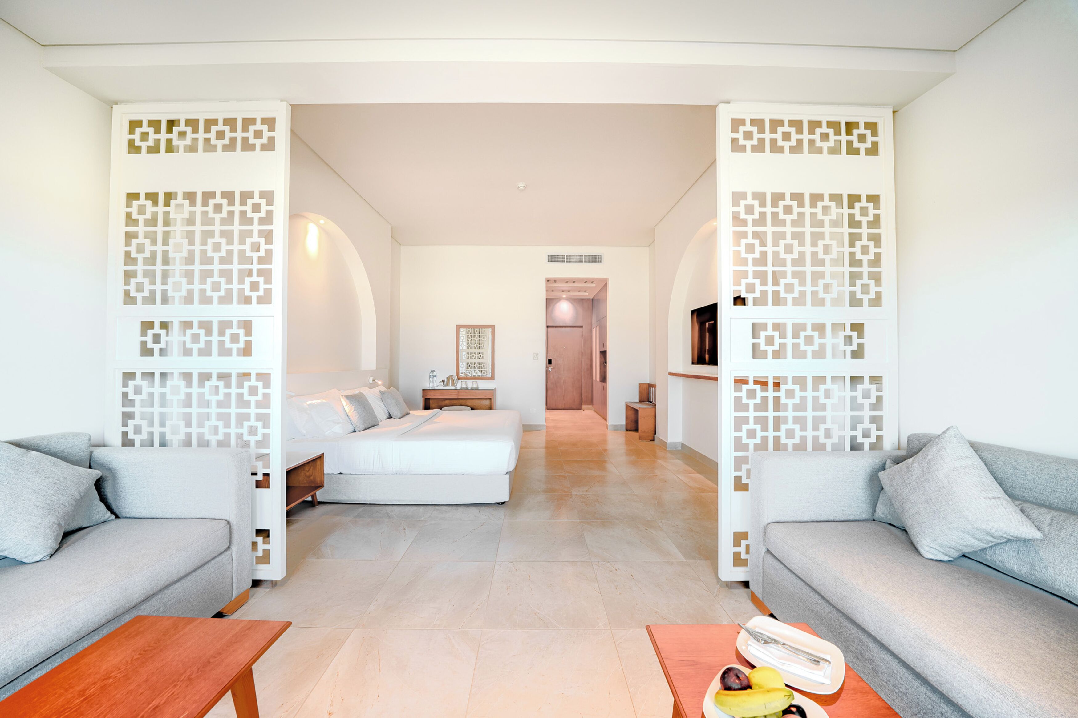 Una habitación de hotel moderna con sofá, cama y zona de comedor.
