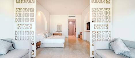 Una habitación de hotel moderna con sofá, cama y zona de comedor.