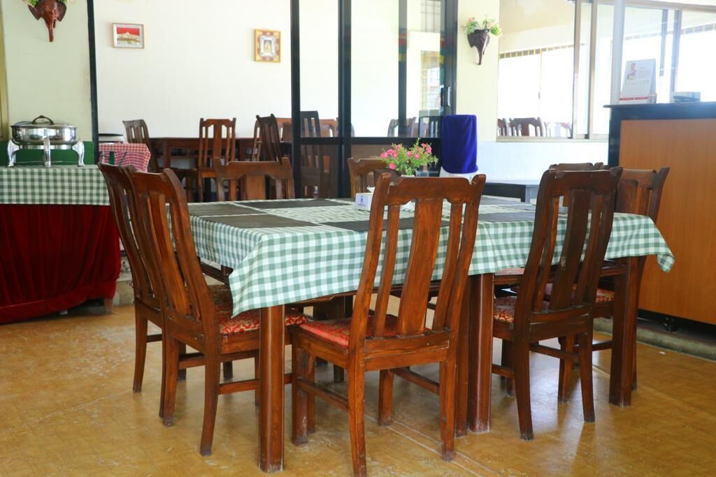 A dining area with wooden chairs and tables covered with checkered tablecloths.