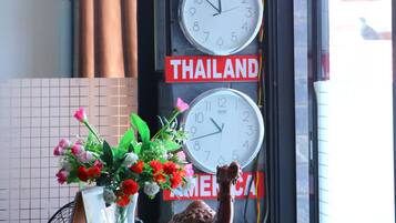 A wall with clocks set to different times and signs indicating Nepal, China, Thailand, and Malaysia.