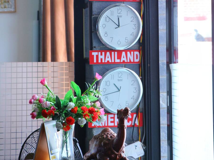 A wall with clocks set to different times and signs indicating Nepal, China, Thailand, and Malaysia.
