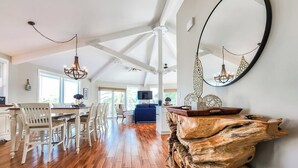 Un loft espacioso con comedor, un espejo grande y una mesa de centro de madera original.