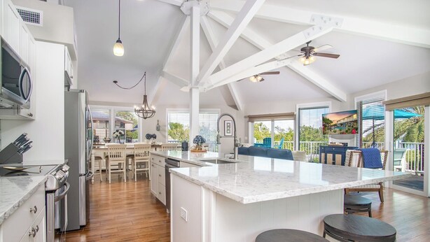 Una cocina amplia con una isla grande, piso de madera y vistas al exterior.