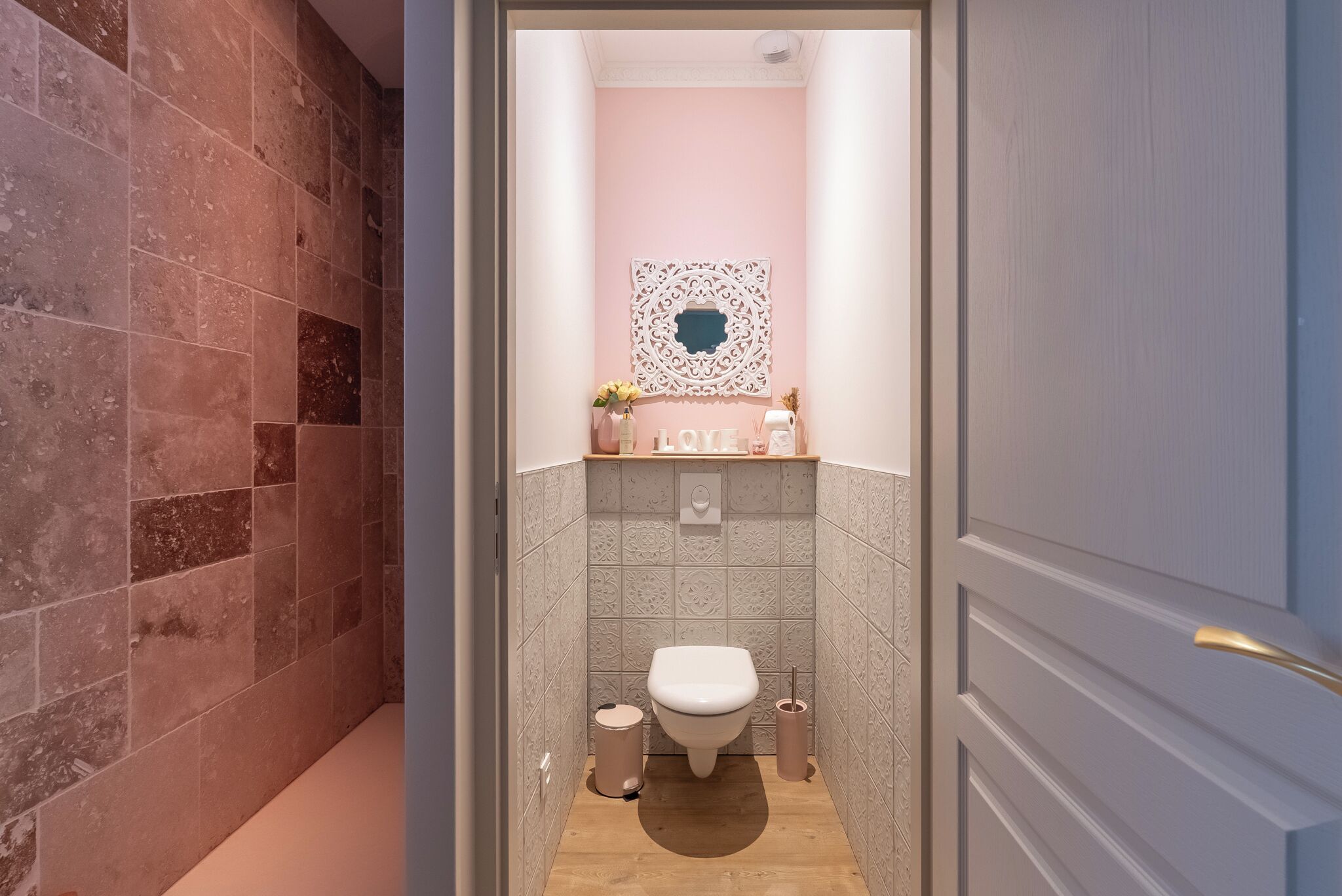 Ein Badezimmer mit Toilette, Waschbecken und einem dekorativen Spiegel.