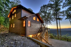 A wooden cabin with a staircase leading to the entrance, surrounded by trees and a view of the landscape. - Altitude Blue Ridge - Awesome Views & 4 King Beds (Blue Ridge)