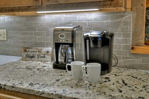 A kitchen with a coffee maker, two white mugs, and a sign that reads 'Welcome to Flight Deck.' - Altitude Blue Ridge - Awesome Views & 4 King Beds (Blue Ridge)