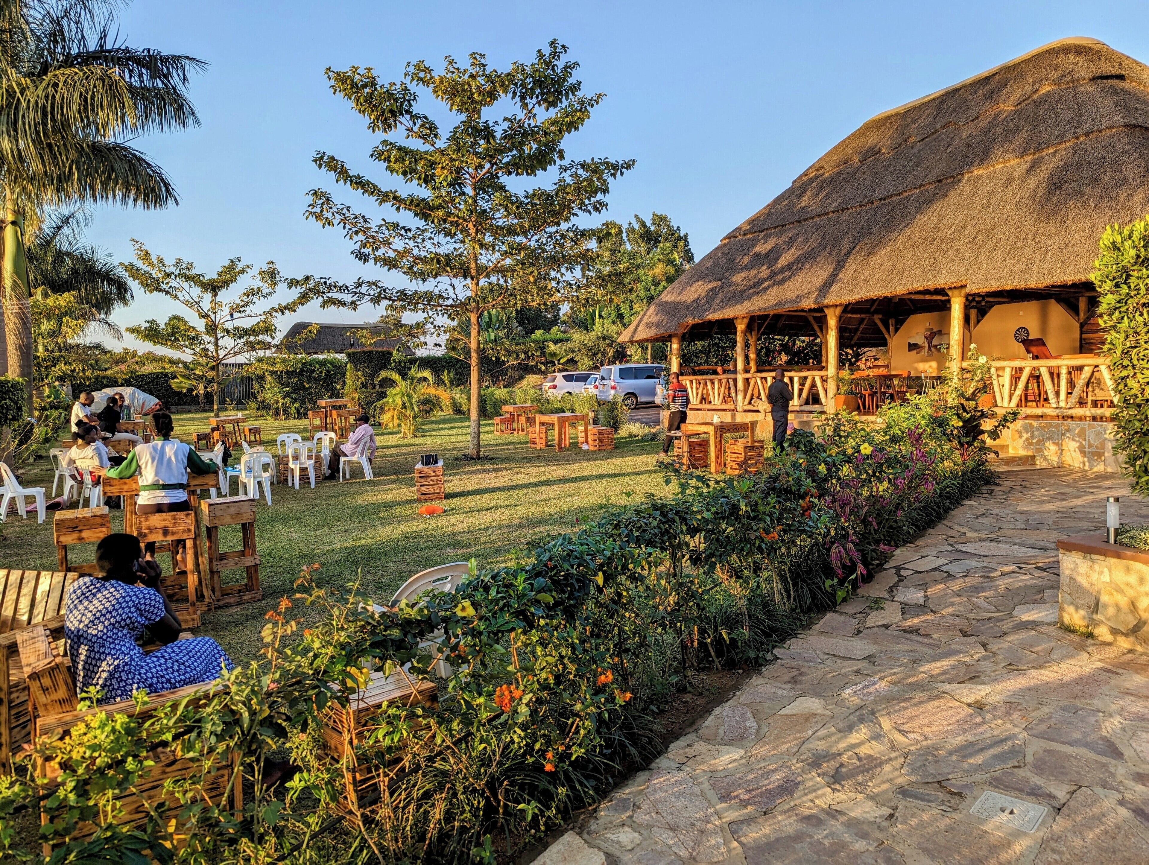 An outdoor seating area with wooden furniture and a thatched-roof structure.