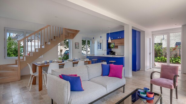 A modern living room with a sofa, coffee table, and a staircase leading to another level. - Modern 8-guest house with garden & BBQ (La Baule-Escoublac)