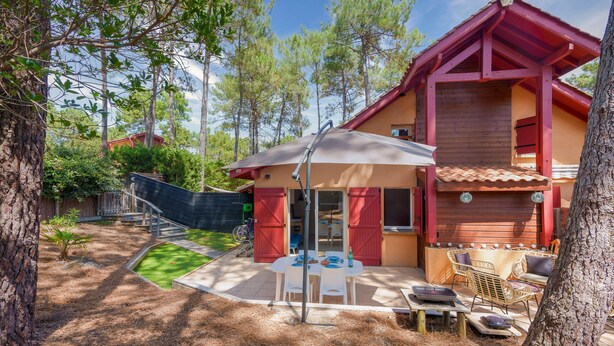 A wooden house with a patio, a table with chairs, and a covered area with a table and chairs. - House for 4 with pool in Lacanau (Lacanau)
