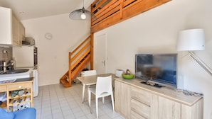A compact kitchen with a dining area, a TV, and a staircase. - House for 4 with pool in Lacanau (Lacanau)