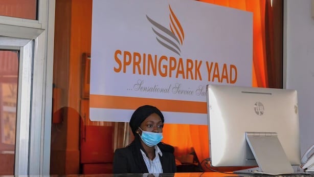 A receptionist at Springpark Yaad with a HP laptop on the desk. - Springpark Yaad Hotel (Lagos)