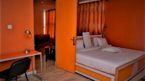 A room with a bed, a desk, and a chair. - Springpark Yaad Hotel (Lagos)