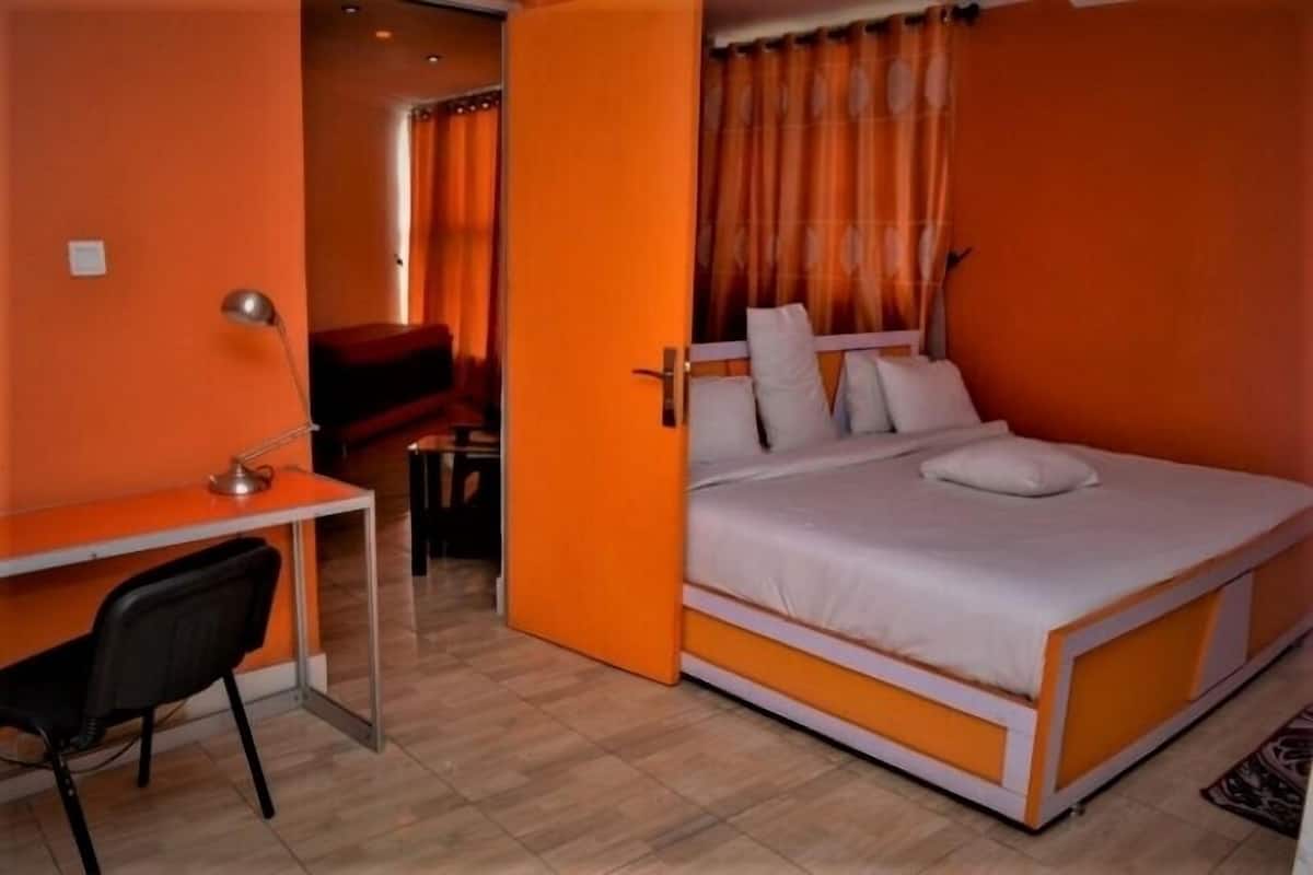 Una habitación con una cama, un escritorio y una silla.
