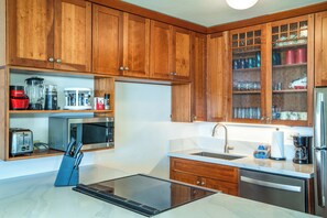 A kitchen with wooden cabinets, a microwave, a toaster, and a sink.