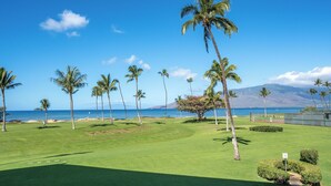 Un parcours de golf offrant une vue dégagée sur l’océan et les montagnes en arrière-plan.