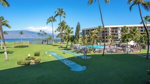 Un parcours de golf doté d’une piscine, de palmiers et d’un bâtiment agrémenté de nombreux balcons.