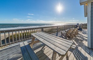 Een houten terras met uitzicht op het strand en de zee.