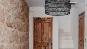 Ein Korridor mit Steinwand, Holztür und Treppe.
