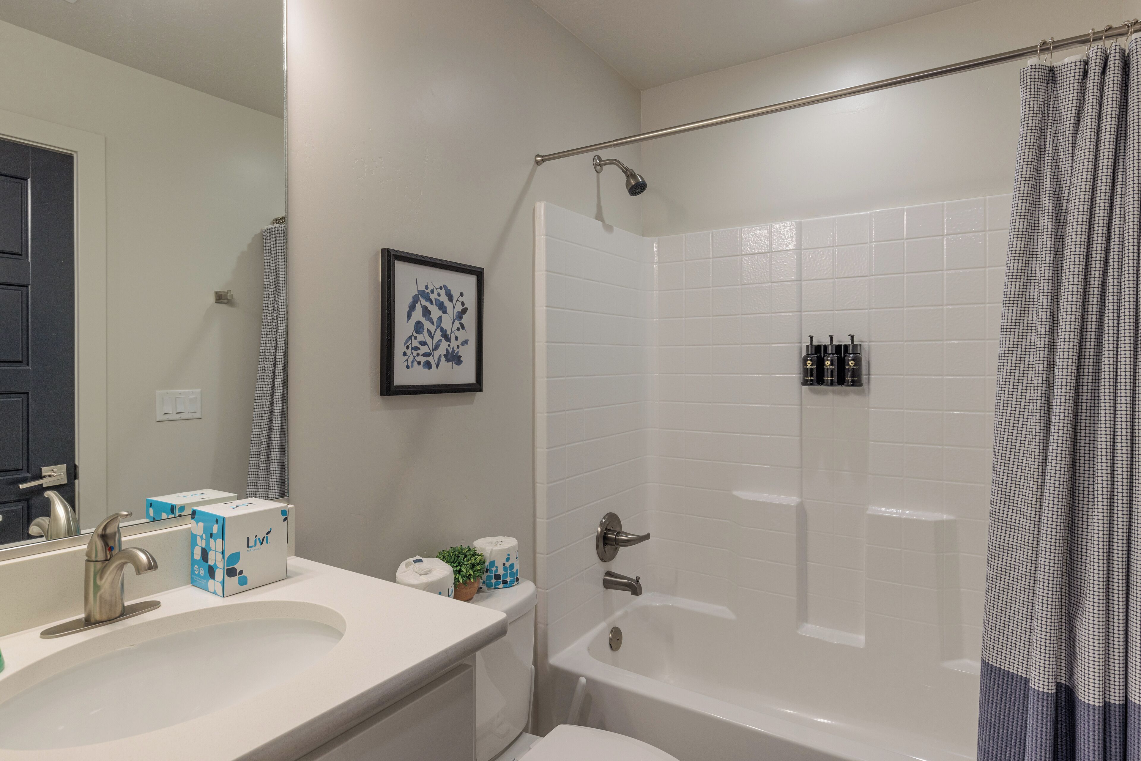 Une salle de bain moderne équipée d’un lavabo, de toilettes et d’une baignoire.