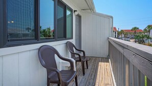 A wooden deck with two chairs and a white railing. - 2 Minutes to the Beach, Condo in Seagrove Beach + Free Attraction Tickets! (Santa Rosa Beach)