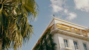 Stunning corner building with balconies and shutters.