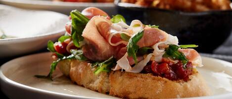 A sandwich on a plate with various toppings.