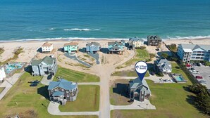 An aerial view of a coastal residential area with houses, a beach, and a clear view of the ocean. - In Due Tide: Oceanside, Hot Tub, Dogs OK (Rodanthe)