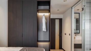 Een moderne slaapkamer met een grote garderobe, een kapstok en een douchecabine met glazen wanden.