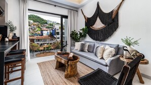 Ein modernes Wohnzimmer mit grauem Sofa, einem Holztisch und einer Wandaufhängung in Form einer Hängematte.