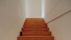 A staircase with wooden steps and white walls.