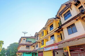 A multi-story building with various shops on the ground floor, including a visible sign for a laundry service. - Hotel O Pelita StayNearAnugrah Sinar Lautan (Batam)