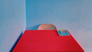 A small room with a red table and a blue wall.
