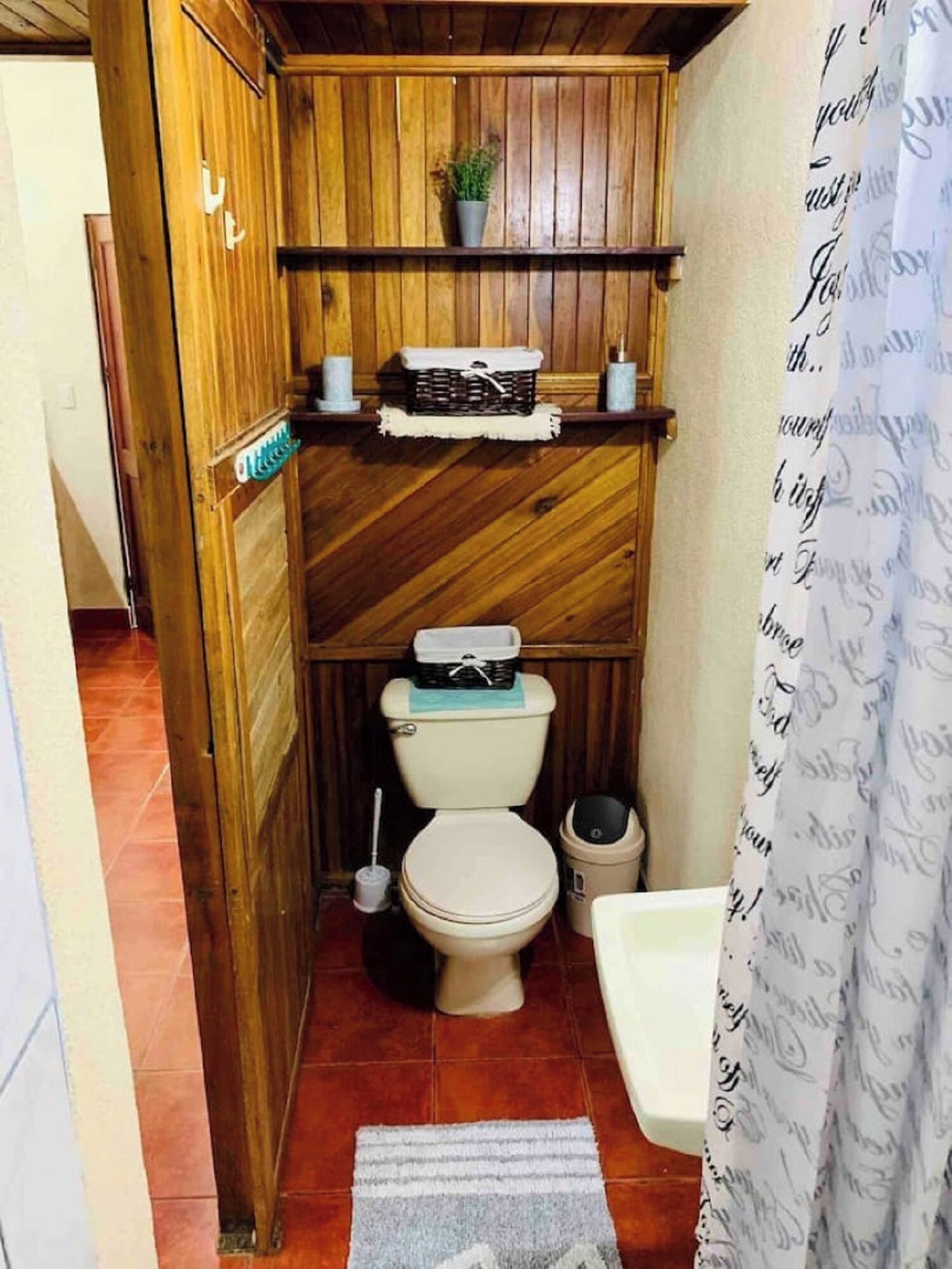 Une petite salle de bain avec un meuble-lavabo en bois, des toilettes et un lavabo.