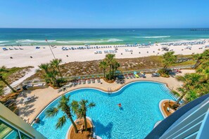 A pool with a view of the beach and ocean.