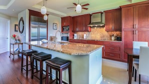 A modern kitchen with granite countertops, stainless steel appliances, and wooden cabinets.