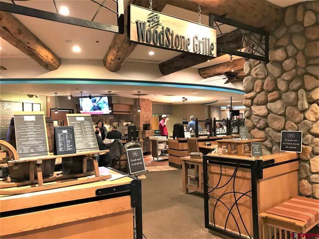 Een restaurantinterieur met een rustieke inrichting, met zichtbare houten balken en stenen muren.