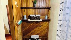 A compact bathroom with a wooden vanity, a toilet, and a sink. - Apartamentos El Labrador # 10 (Tamarindo)