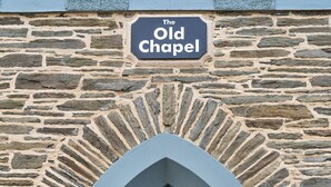 Een stenen gebouw met een bord waarop 'The Old Chapel' staat.