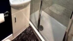 A modern bathroom with a glass shower enclosure, a pedestal sink, and a mirror above the sink. - Perfect stay with Dallas Studio (Hayes)