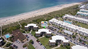 A coastal residential area with modern apartment buildings, a beach, and a parking lot. - Southwinds G16 (Ocean View) (Atlantic Beach)