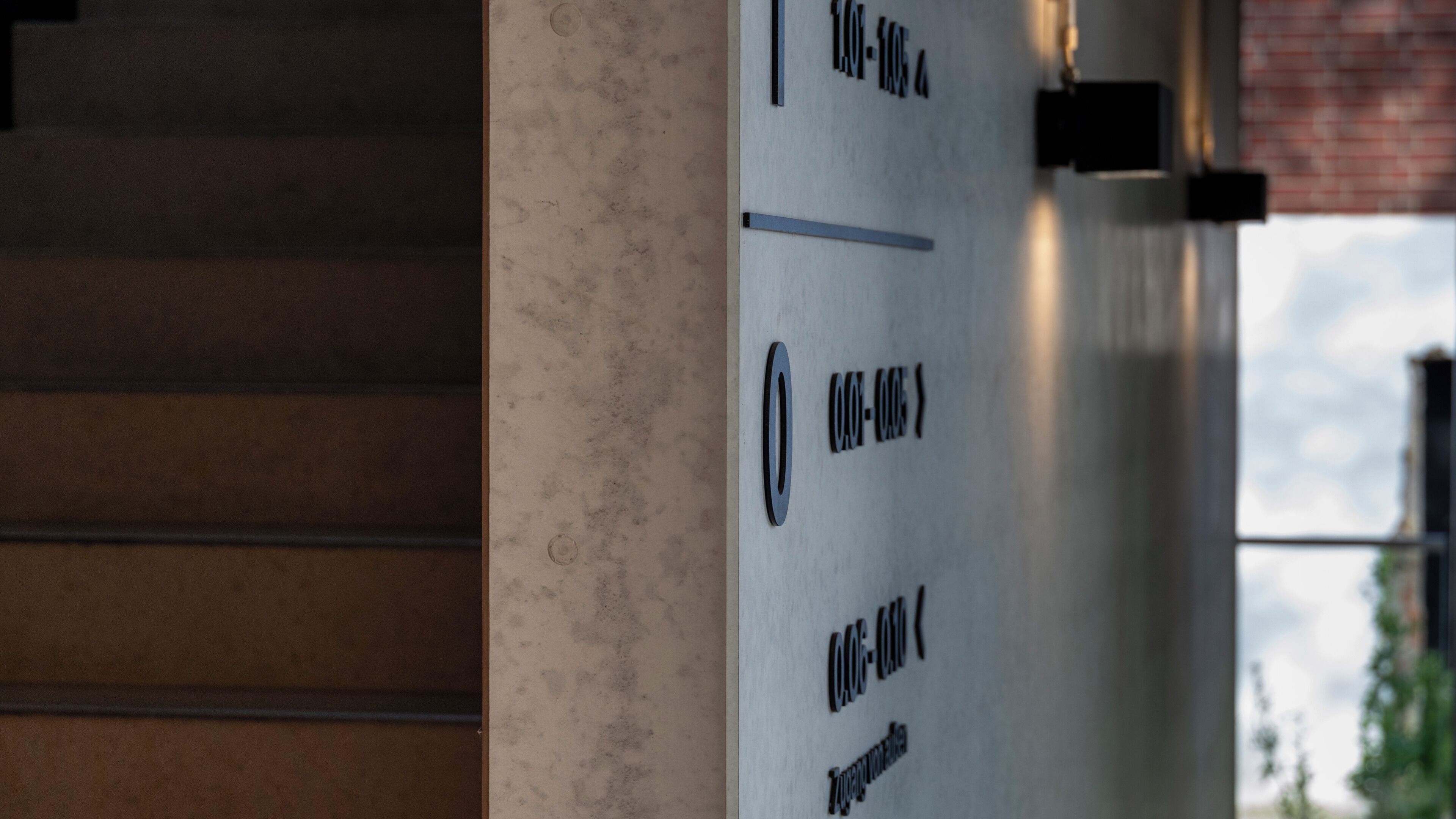 Un mur orné d’une série de chiffres et de lettres, qui indique probablement les numéros des pièces ou les désignations des bureaux.