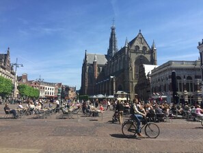 Una plaza histórica con una iglesia destacada, zonas de estar al aire libre y diversos edificios.
