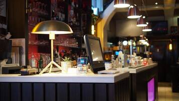 A bar counter with a computer, a cash register, and a payment terminal.