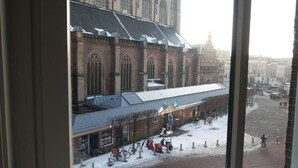 A view of a historic building with large windows and a covered entrance. - Hotel Carillon (Haarlem)