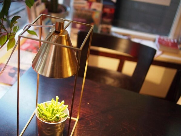 A metallic lamp with a geometric base on a wooden table.