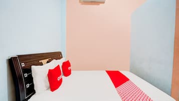 Una cama con un colchón blanco, almohadas rojas y una colcha roja y blanca.