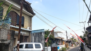 A residential street with houses, a parked car, and a crane. - OYO Life  92842 Homestay Balearjosari (Malang)