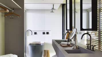 A modern bathroom with a large sink, mirror, and towel rack.